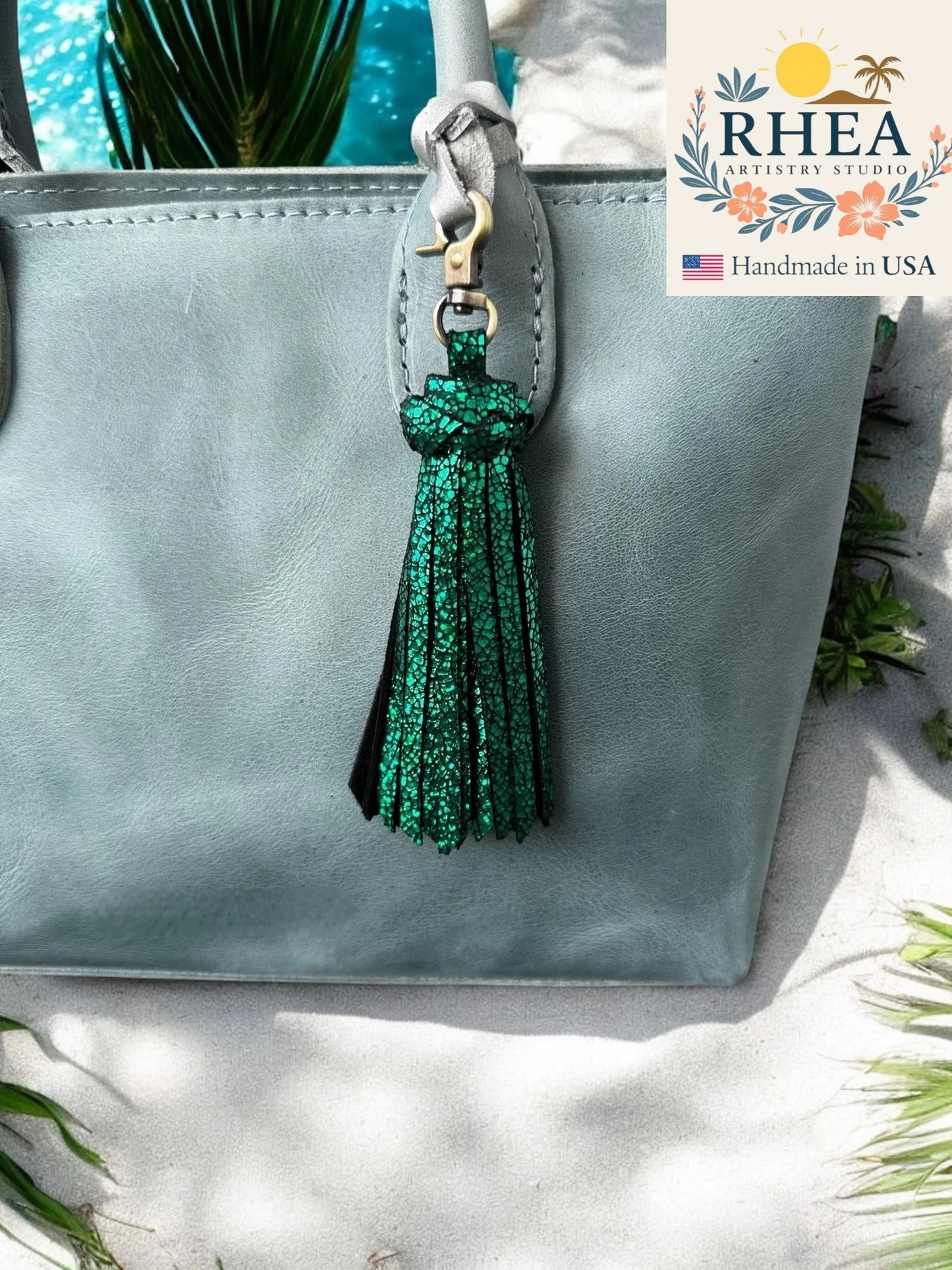 emerald green tassel on a gray bag with RHEA branding