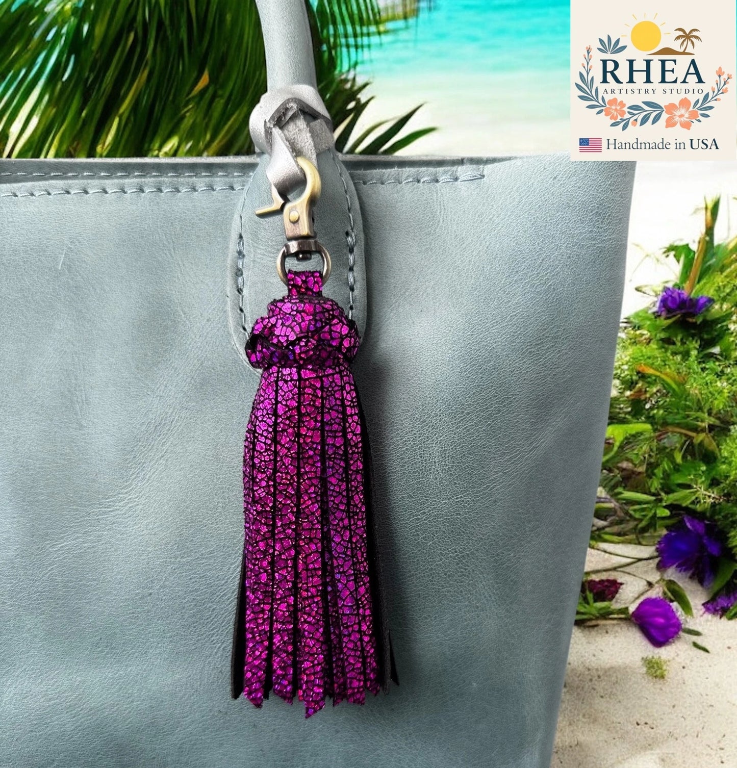 Purple tassel keychain attached to a gray bag with a blurred natural background