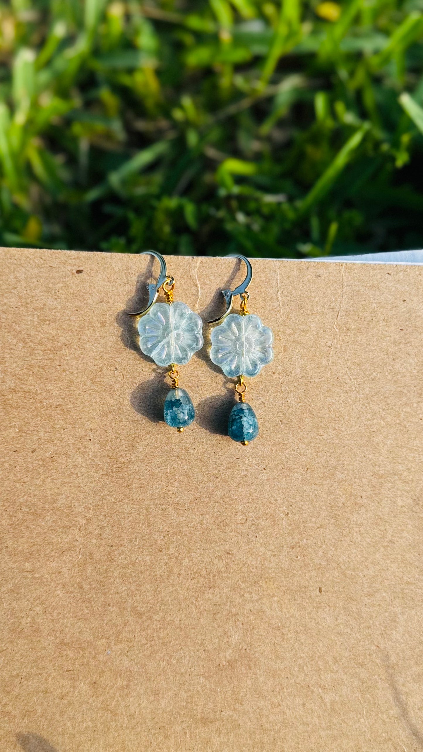 Floral earrings with blue beads on an old book