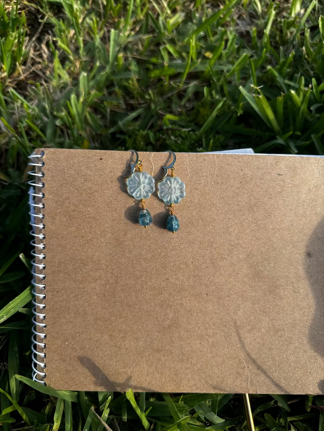 Floral earrings with blue beads on an old book
