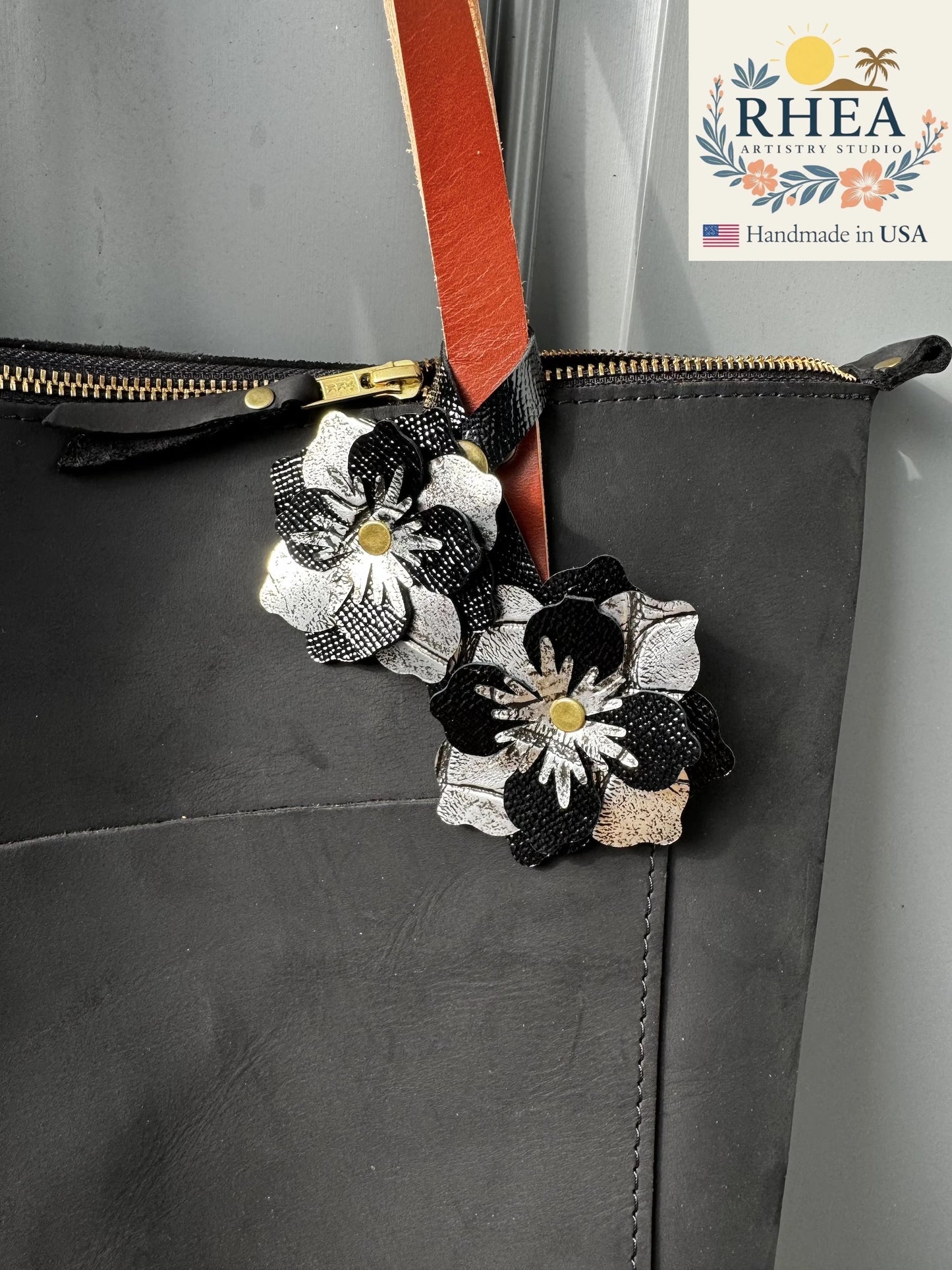 Close-up of the Everbloom Leather Bag Charm Double in black and silver, featuring two layered handcrafted blossoms with soft metallic and matte finishes.