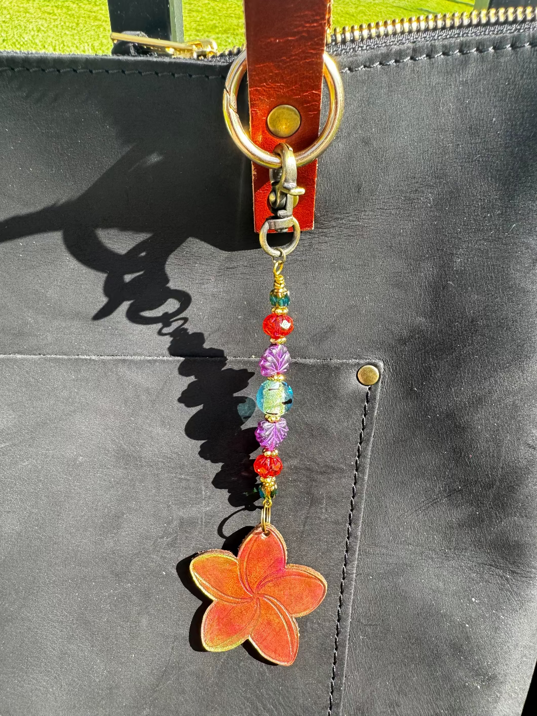 Flower-shaped keychain with beads on a black bag