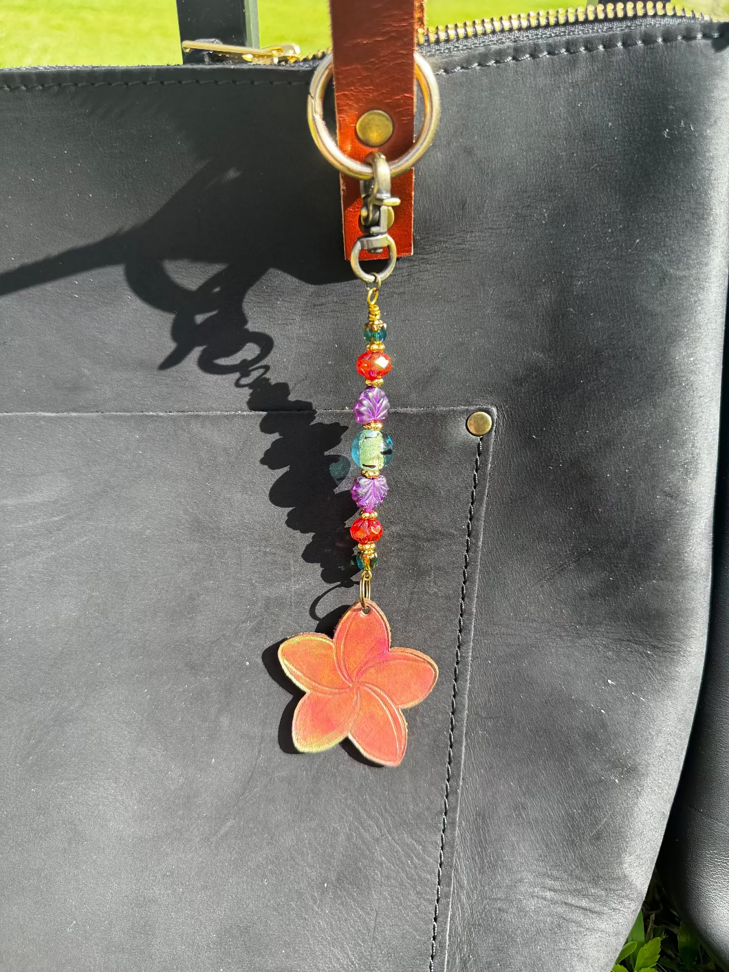Flower-shaped keychain with beads on a black bag