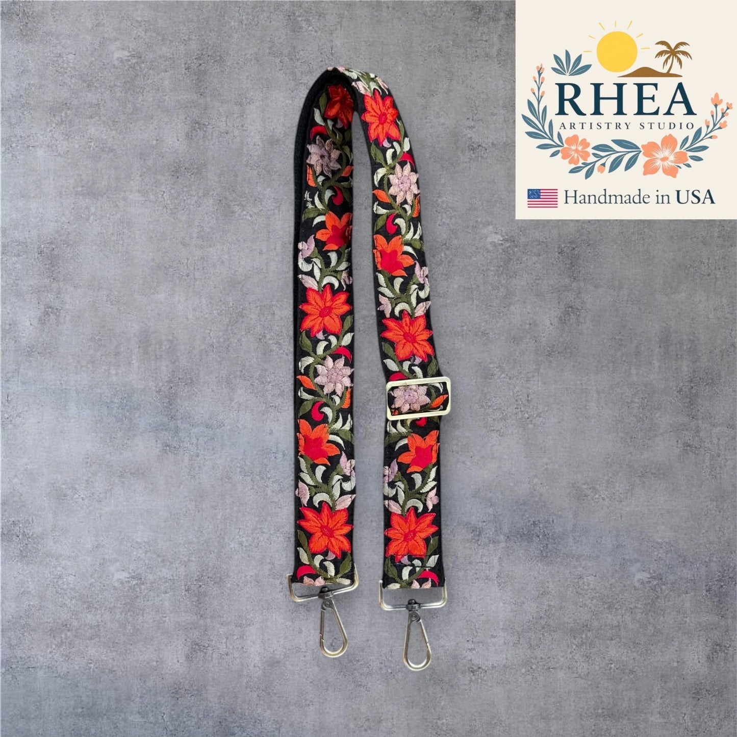 Floral patterned purse strap on a gray background with RHEA Artistry Studio logo.
