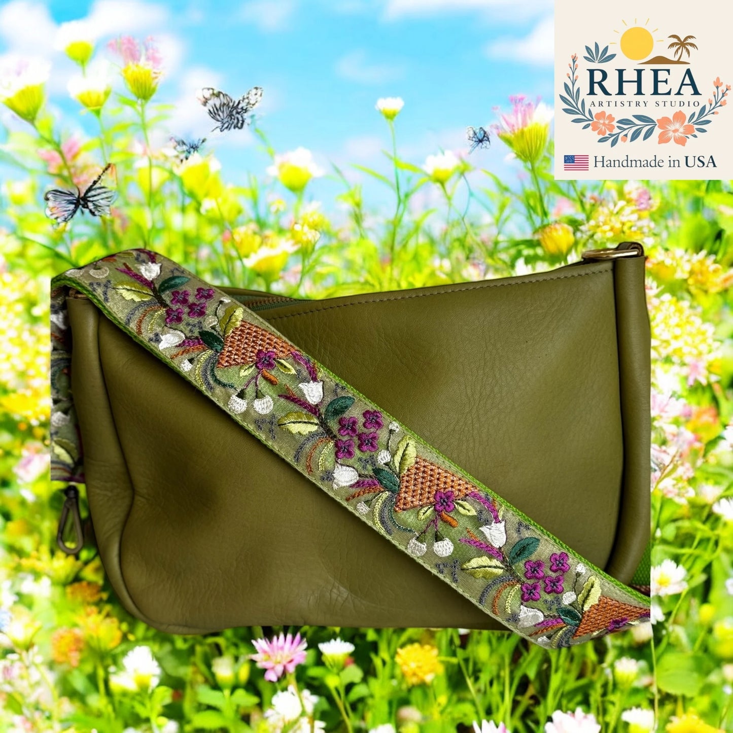 Green handbag with floral embroidery purse strap on a background of flowers and butterflies, featuring the RHEA Artistry Studio logo.