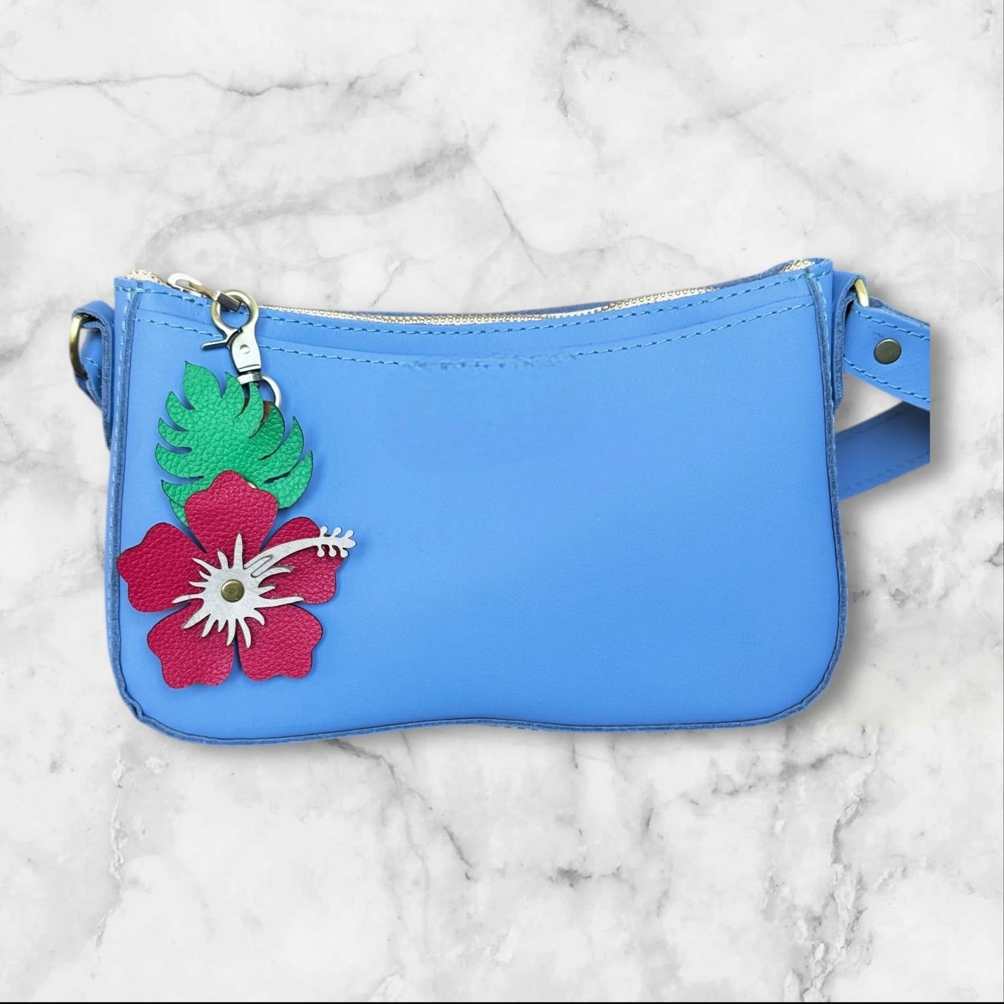 Red with blush stamen leather hibiscus flower on a blue bag for tropical vibe
