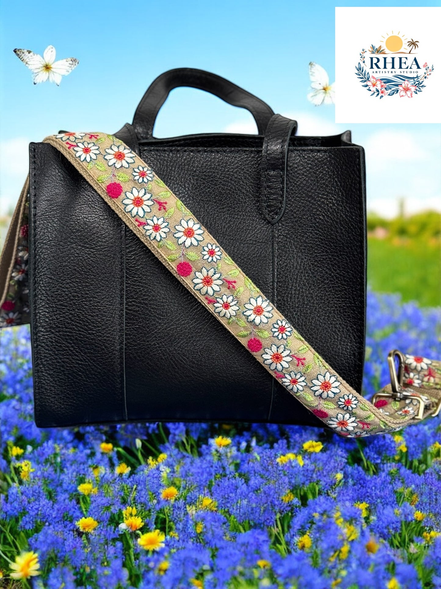 A black purse with a floral embroidered purse strap placed on a surface with flowers in the background.