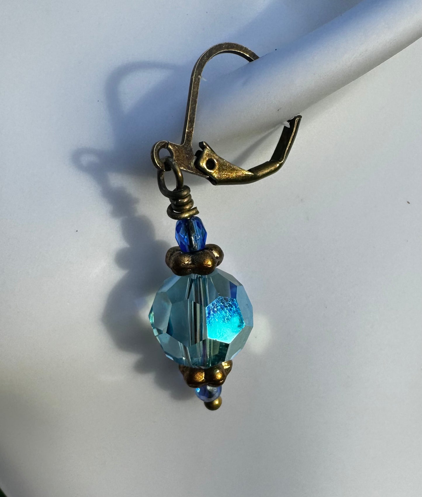 Gold and blue beaded earrings on a model