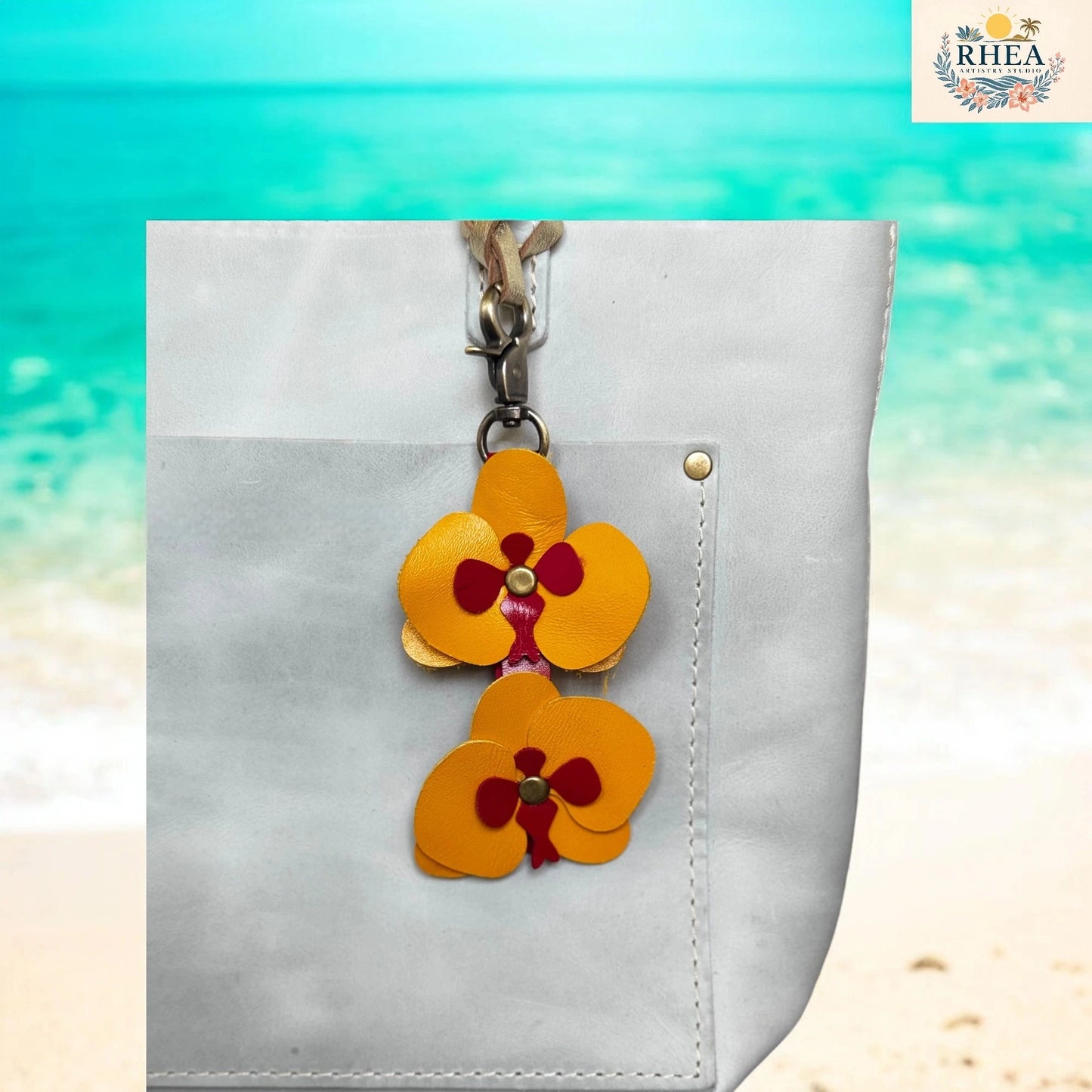 Floral keychain attached to a white bag with a beach background