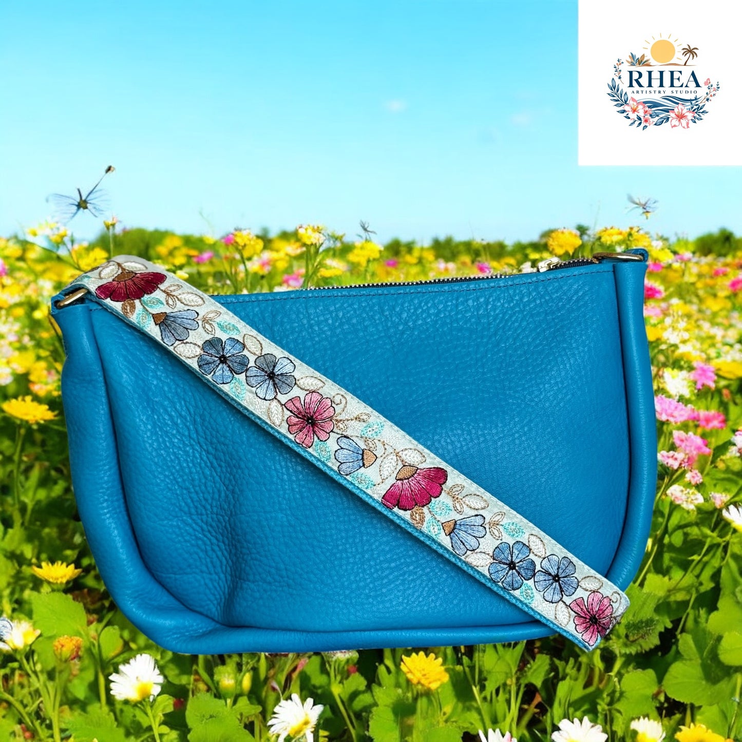 Aqua leather bag with light blue strap featuring floral embroidery in aqua, lime, and gold.