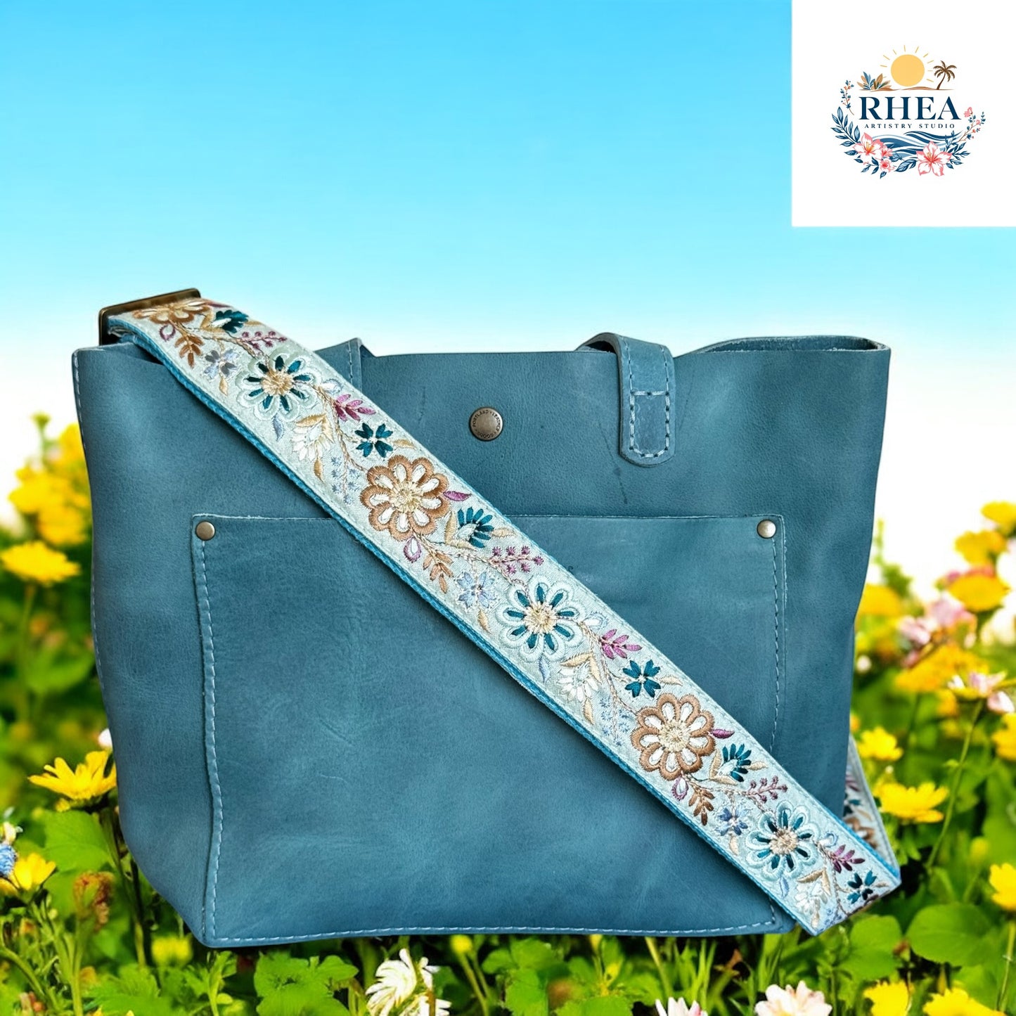 This vibrant aqua floral strap features intricately embroidered blossoms in shades of teal, cream, and bronze. A perfect replacement or upgrade for your favorite bag, it brings a fresh pop of color and artisan charm at the garden