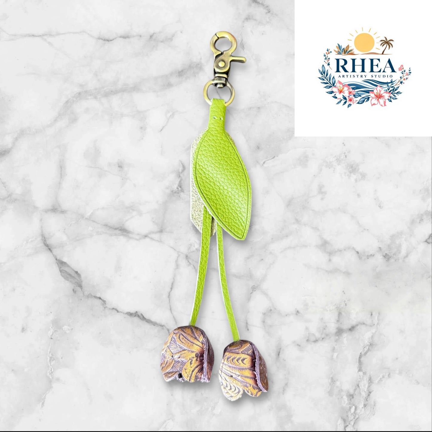 Handcrafted leather tulip charm with green leaf and copper floral buds, ideal for bags or keychains.