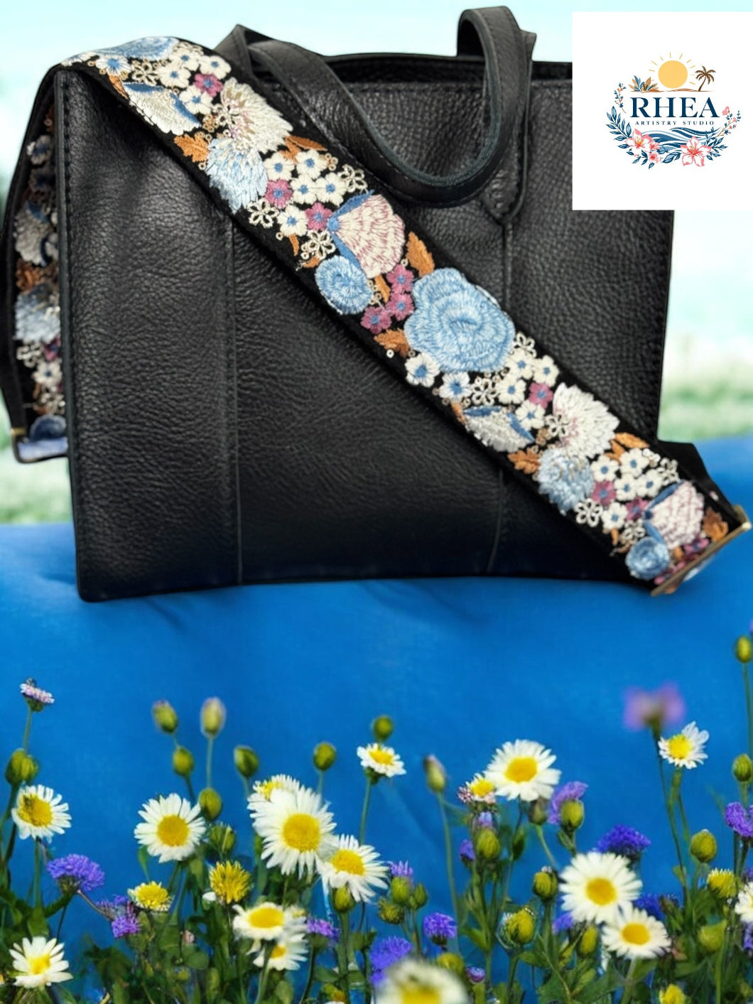 Black leather bag with richly embroidered wide strap featuring sky blue and ivory jumbo roses by Rhea Artistry Studio.