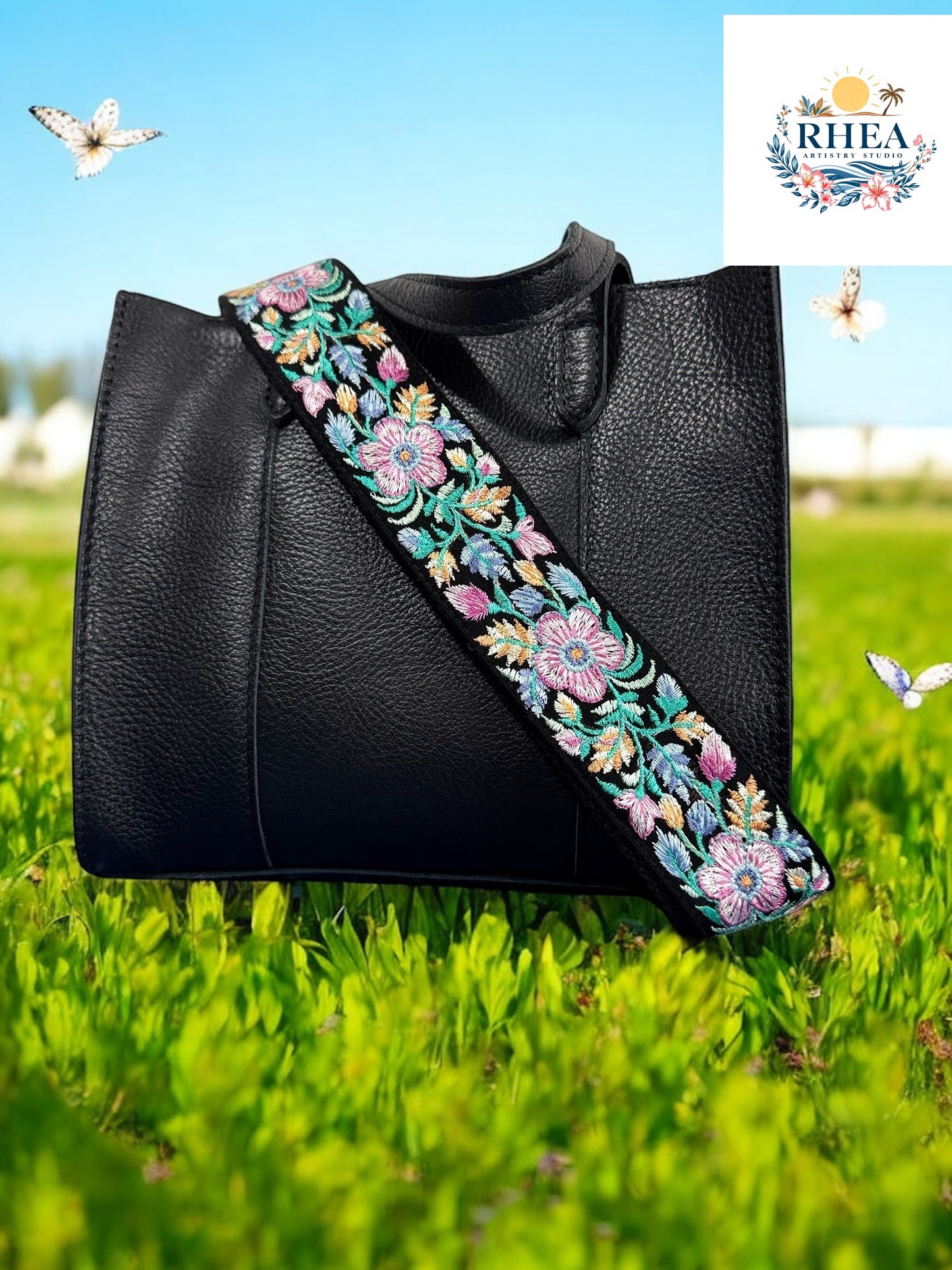 A black purse with a black plum floral embroidered purse strap set against a field of colorful flowers.