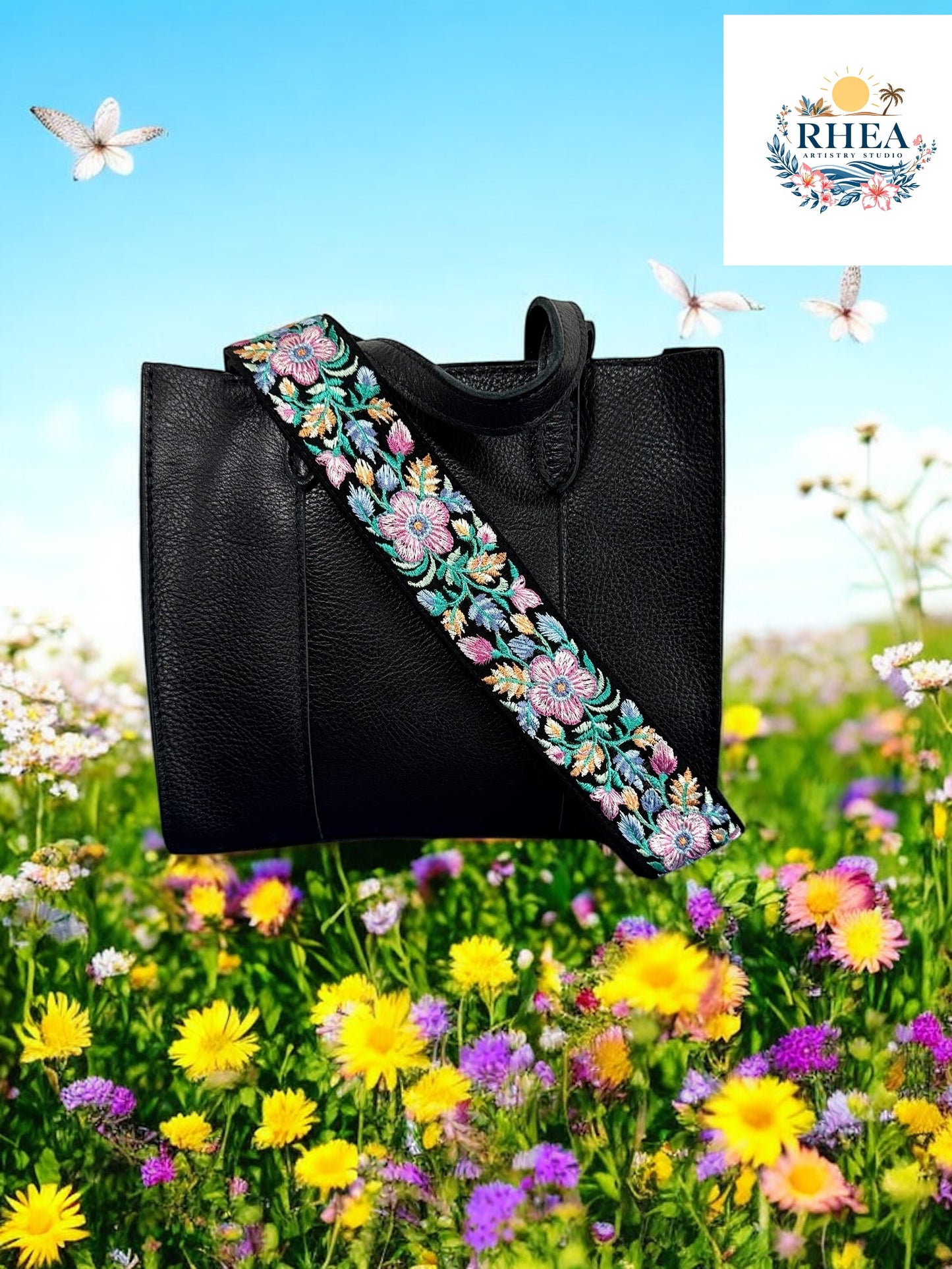 A black purse with a black plum floral embroidered purse strap set against a field of colorful flowers.