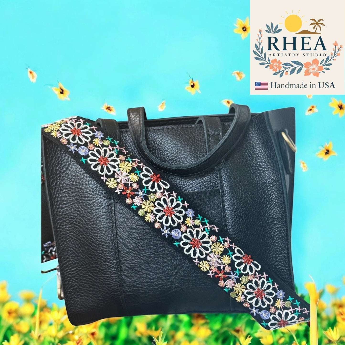 Black handbag with colorful floral strap on a blue background with flowers