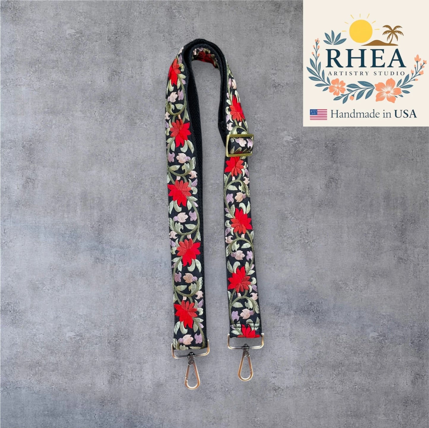 Floral patterned purse strap on a gray background with Rhea Artistry Studio logo.