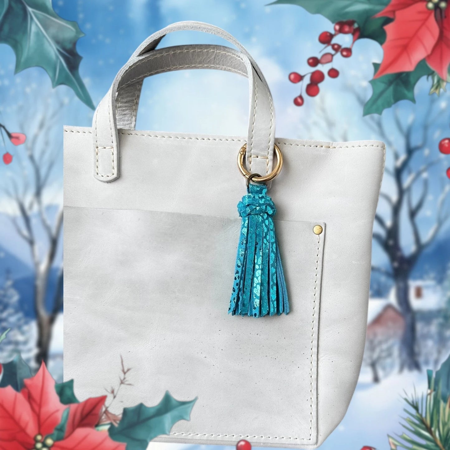 White handbag with a blue tassel against a festive background with holly and poinsettias.