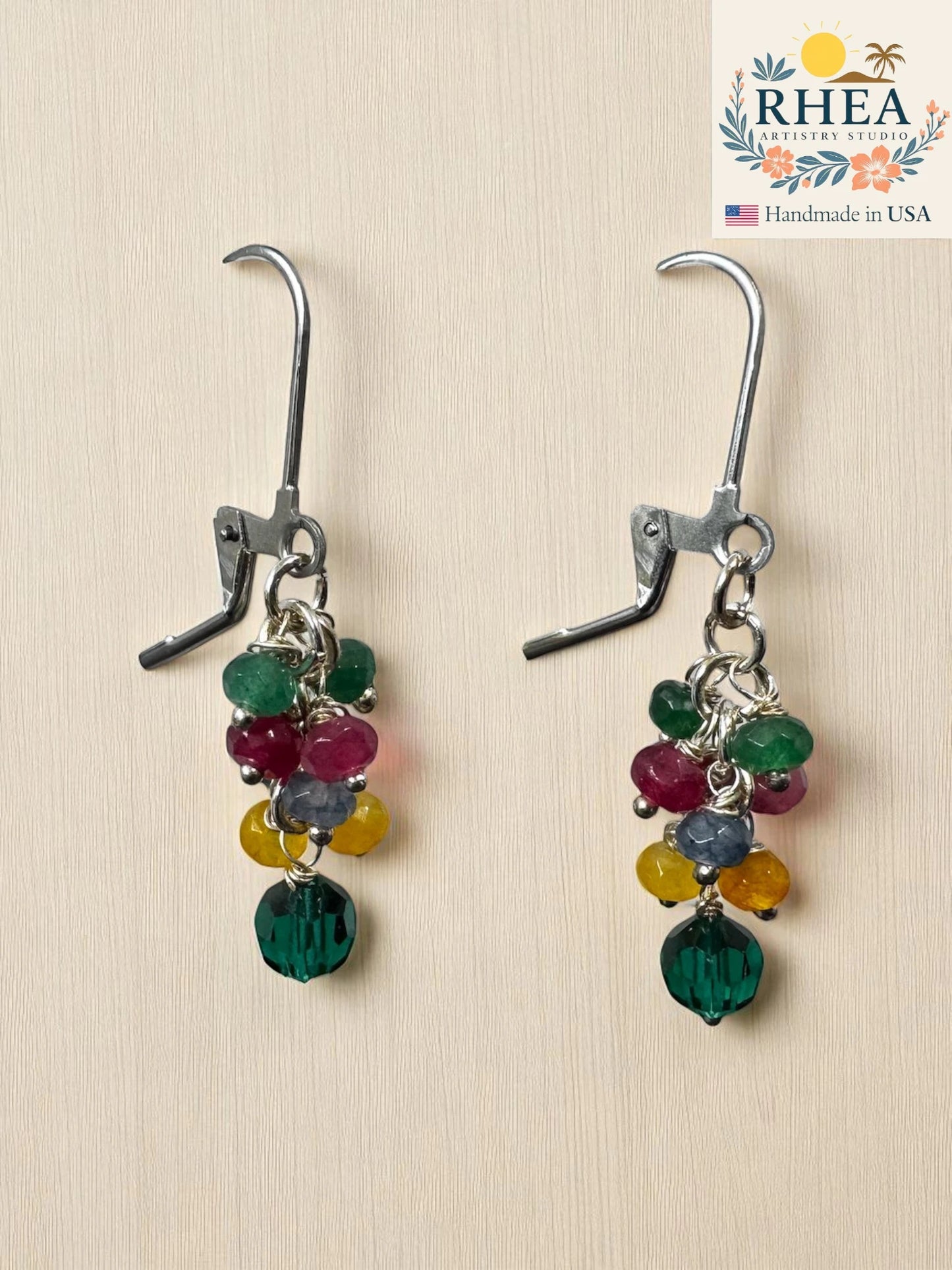 Beaded ear rings with multicolored beads on a beige background, featuring the RHEA brand.
