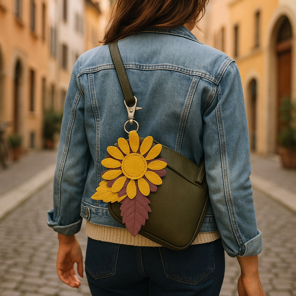 Hand-sewn leather daisy charm in marigold and plum with brass clasp and textured leaves