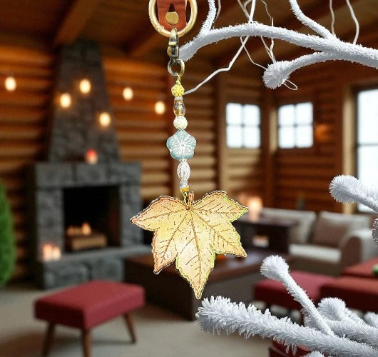 Decorative leaf ornament hanging on a branch with a cozy living room in the background