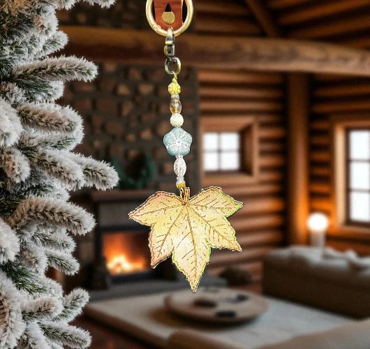 Decorative leaf ornament hanging from a tree in a cozy living room with a fireplace.