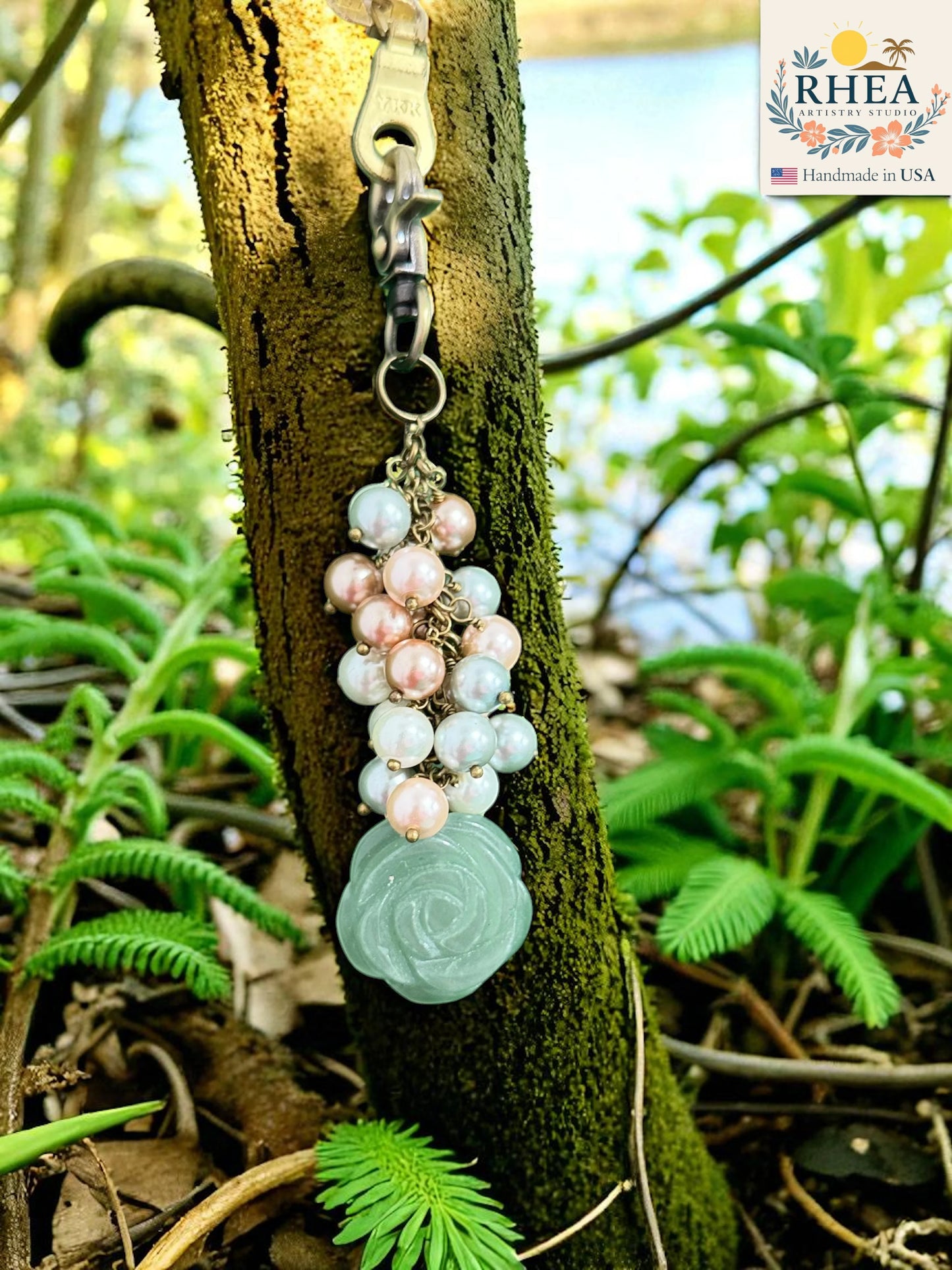 Decorative keychain with beads and a rose-shaped charm on a tree branch with a natural background