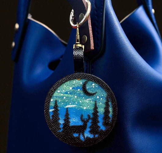 Keychain with bear and moon design on a blue bag