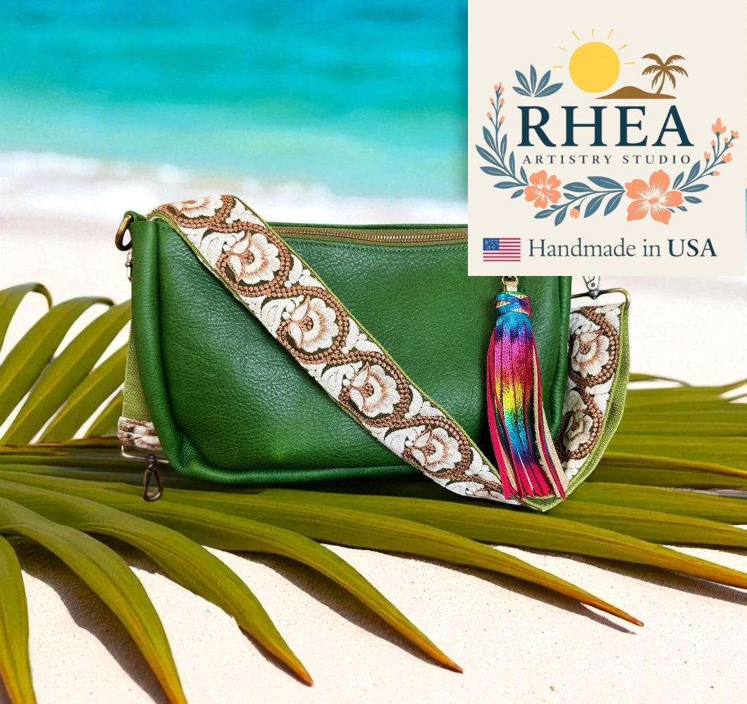 Green handbag with decorative purse strap and tassel on a beach background, featuring RHEA Artistry Studio logo.
