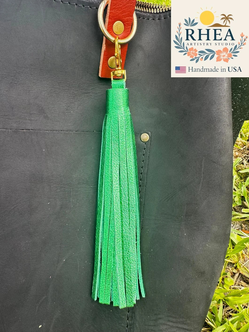 emerald Green tassel on a black bag with RHEA Artistry Studio branding.