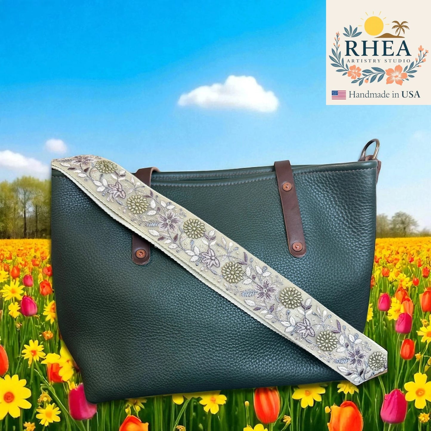 Green leather bag with floral strap in a field of flowers, RHEA brand visible