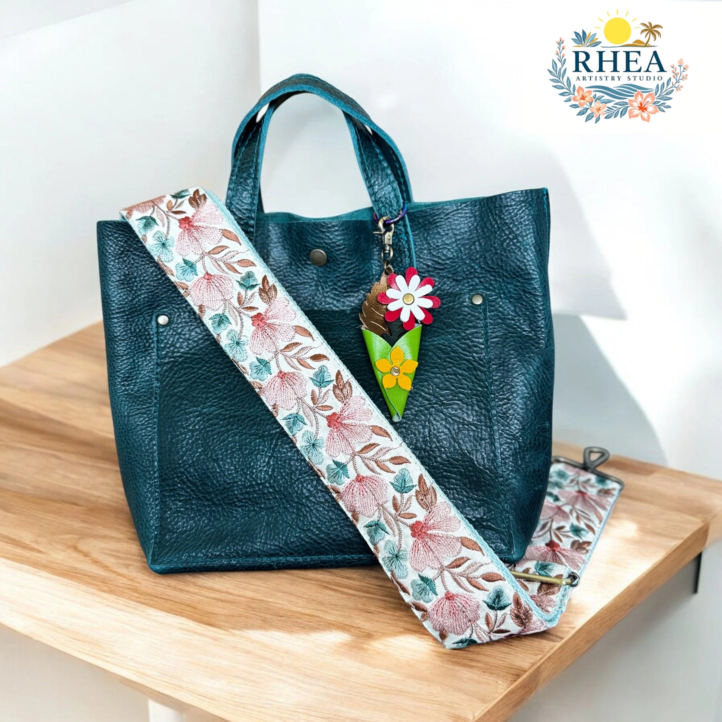A handcrafted mini leather bouquet charm with colorful floral layers including a white-and-red daisy and a yellow flower, nestled in a lime green cone-shaped wrap with leafy accents. Finished with an antique brass lobster clasp, perfect as a bag charm or keychain.