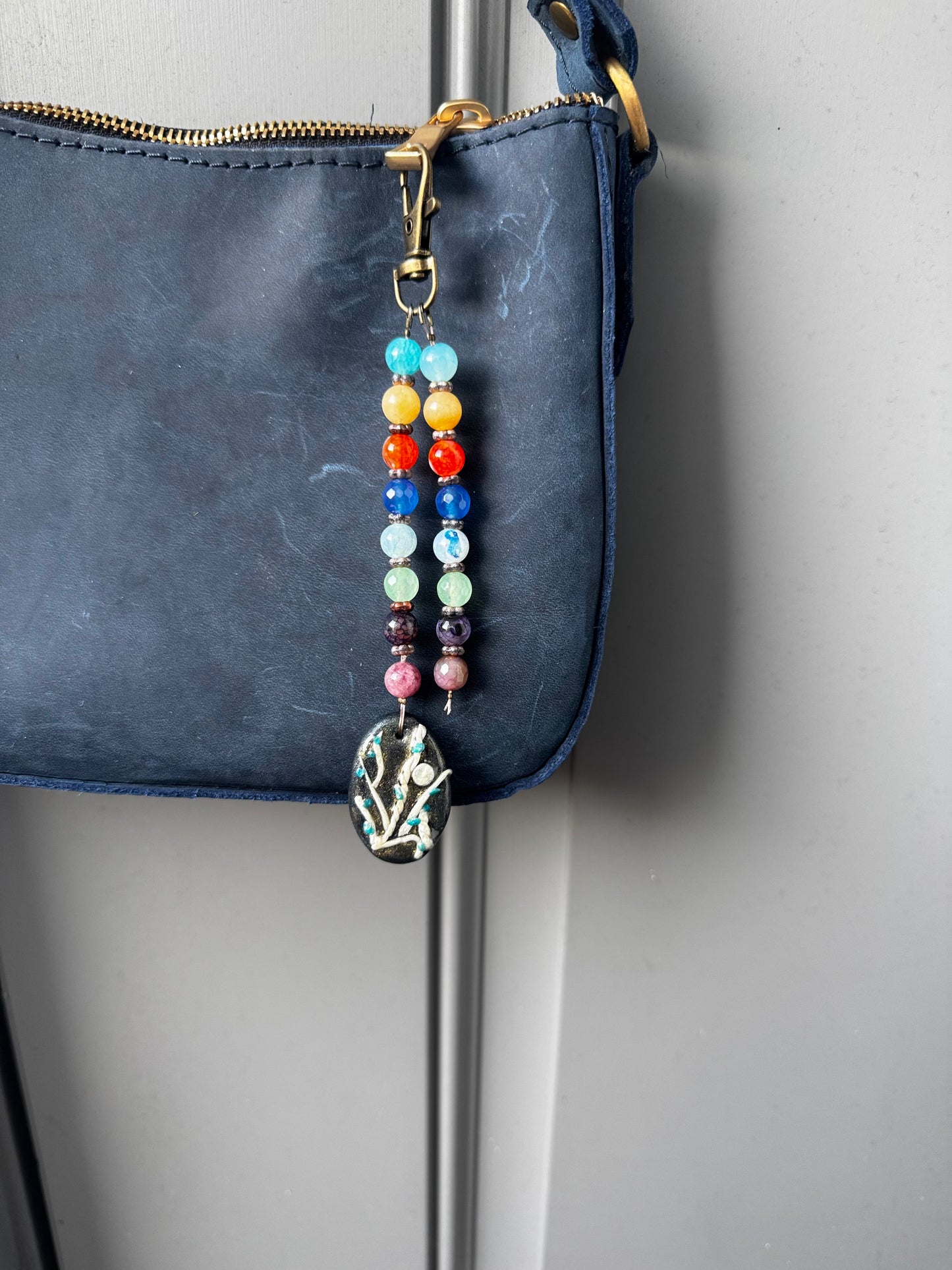 multi colored beaded on 2 strands with a handmade colorful pendant with lobster clasp