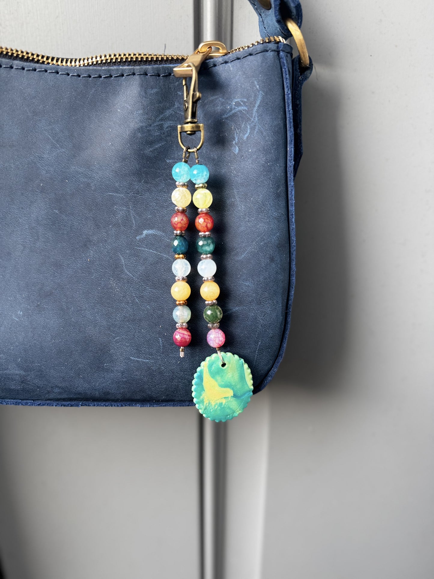 multi colored beaded on 2 strands with a handmade colorful pendant with lobster clasp