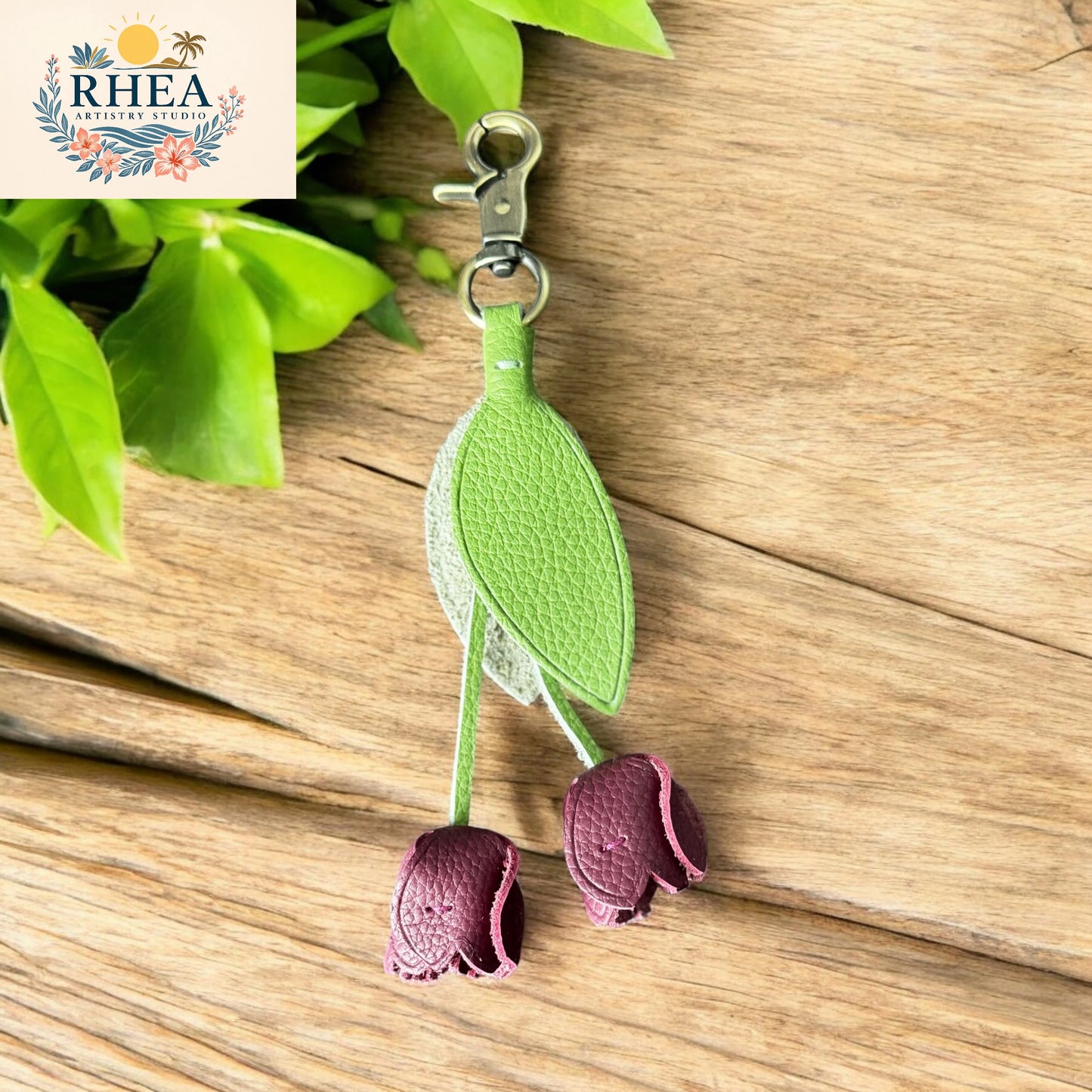 Plum purple leather tulip keychain with green leaf accents, ethically made by Rhea Artistry Studio. Premium handmade floral charm for handbags, backpacks, or keyrings.
