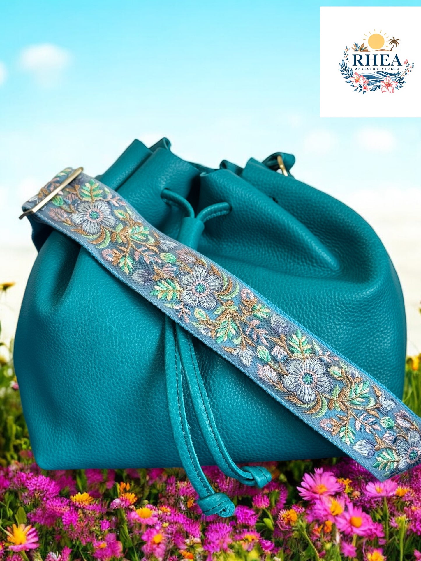 A black purse with a floral embroidered purse strap set against a field of colorful flowers.