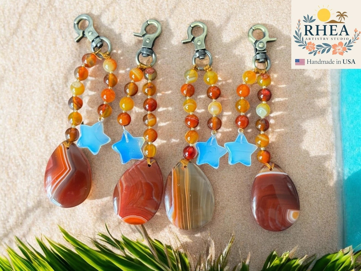 Rhea Artistry Studio handmade agate and moonstone star bag charm with teardrop pendant. Warm orange, yellow, and red beads.