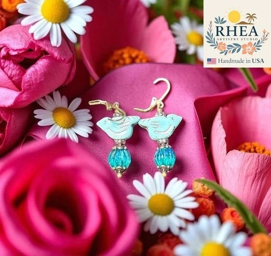 Rhea Artistry Studio light blue bird earrings with blue glass pumpkin beads and brass hardware, approx. 1-1.5 inches long.