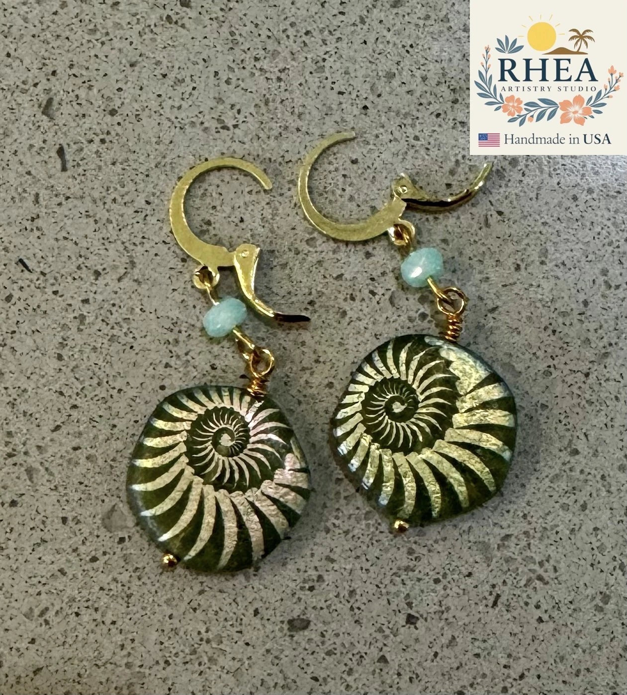 Rhea Artistry Studio gold plated brass earrings with laser etched sea foam green Czech glass beads in ammonite fossil design.