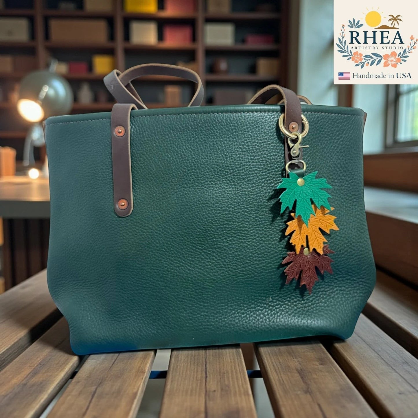 Rhea Artistry Studio layered maple leaf leather bag charm in green, yellow, and brown with vein detail and brass hardware.