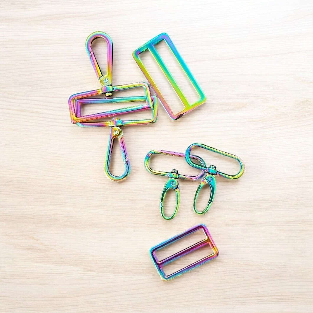 Rhea Artistry Studio rainbow iridescent hardware set including swivel clasps, strap adjusters, and D-rings for bag making.