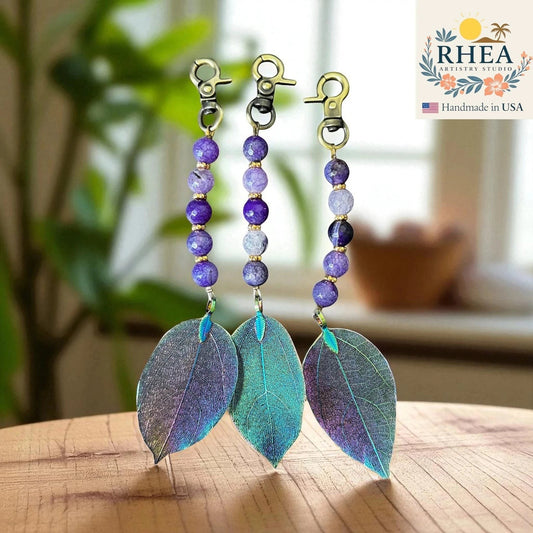 Rhea Artistry Studio handmade violet gemstone and electroplated leaf bag charm with gold clasp.