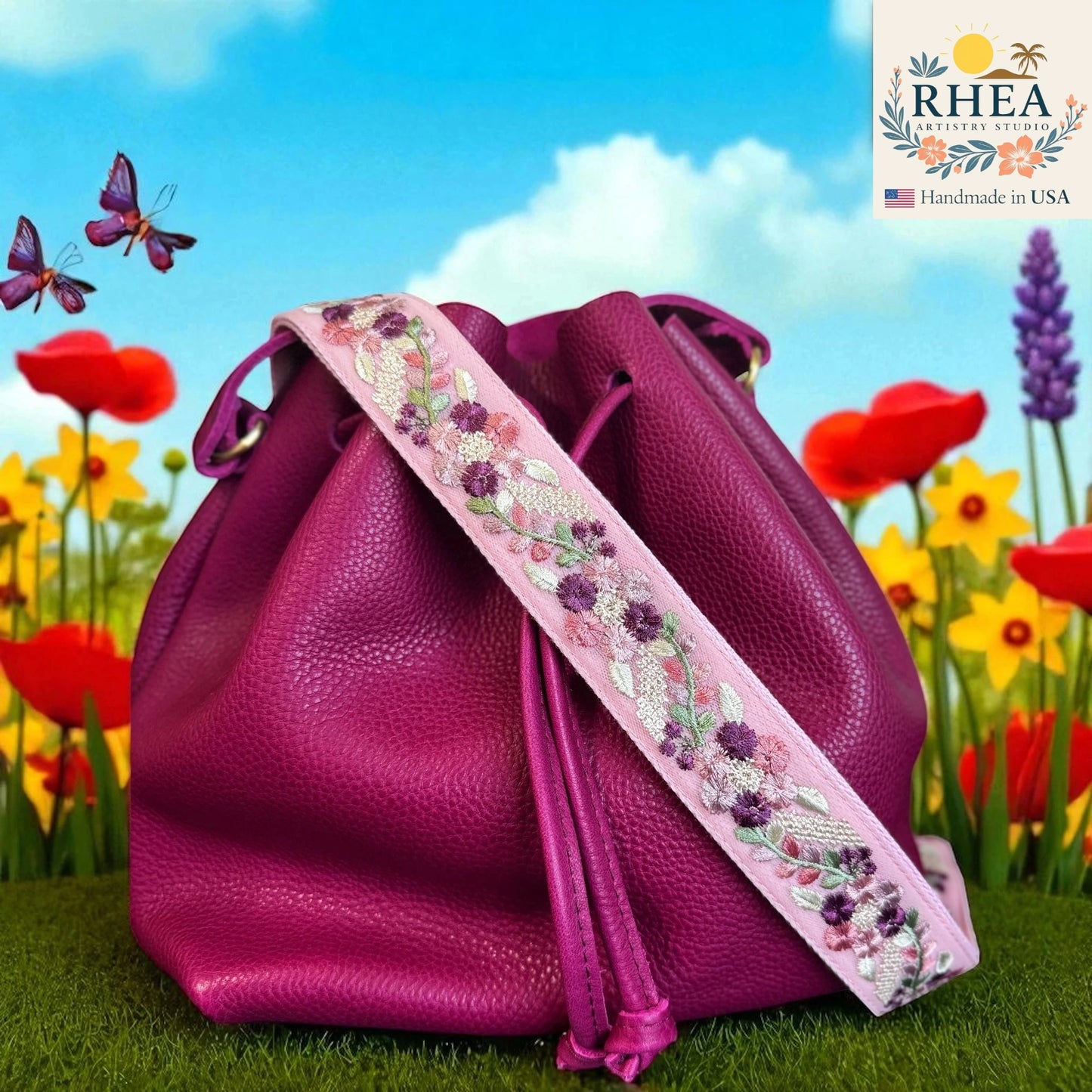 Purple leather bag with floral strap in a garden setting, featuring the RHEA brand.