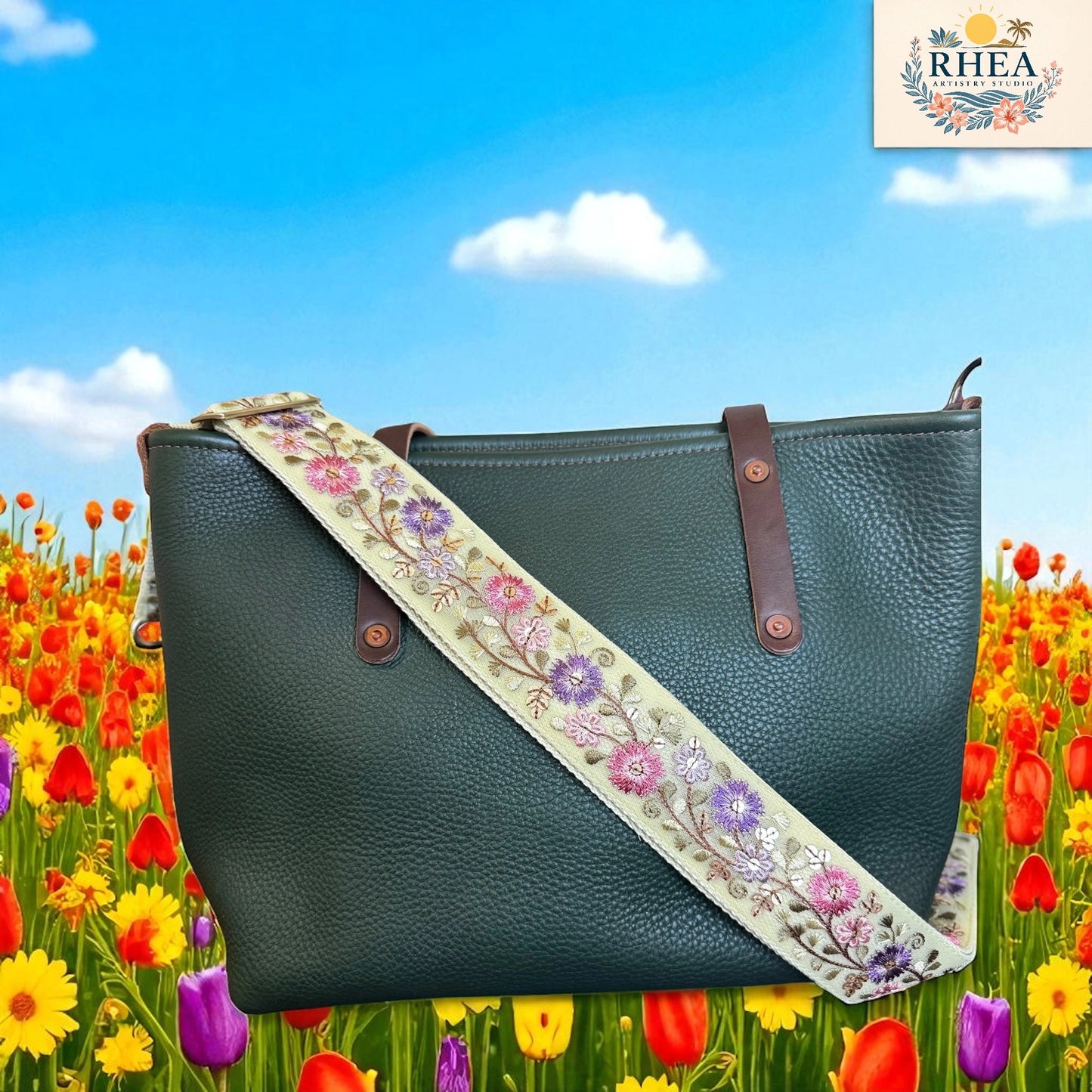 Green handbag with floral strap against a colorful field of flowers and blue sky