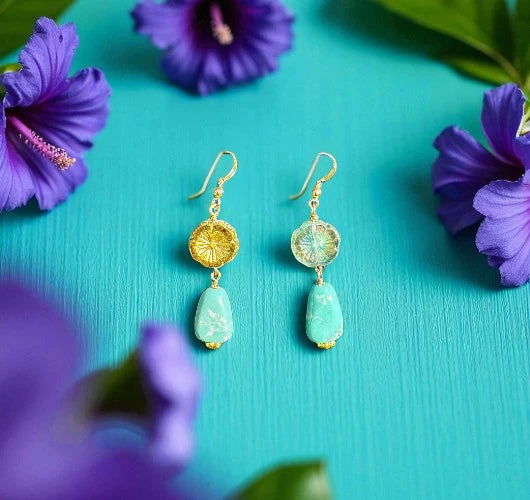 Gold and turquoise earrings on a teal background with purple flowers.