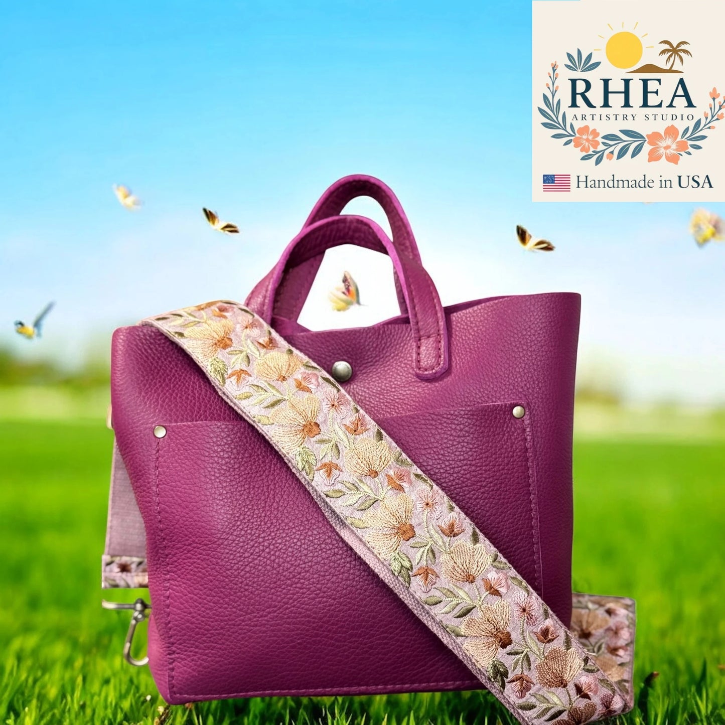 Purple handbag with floral strap on grass, RHEA Artistry Studio logo visible