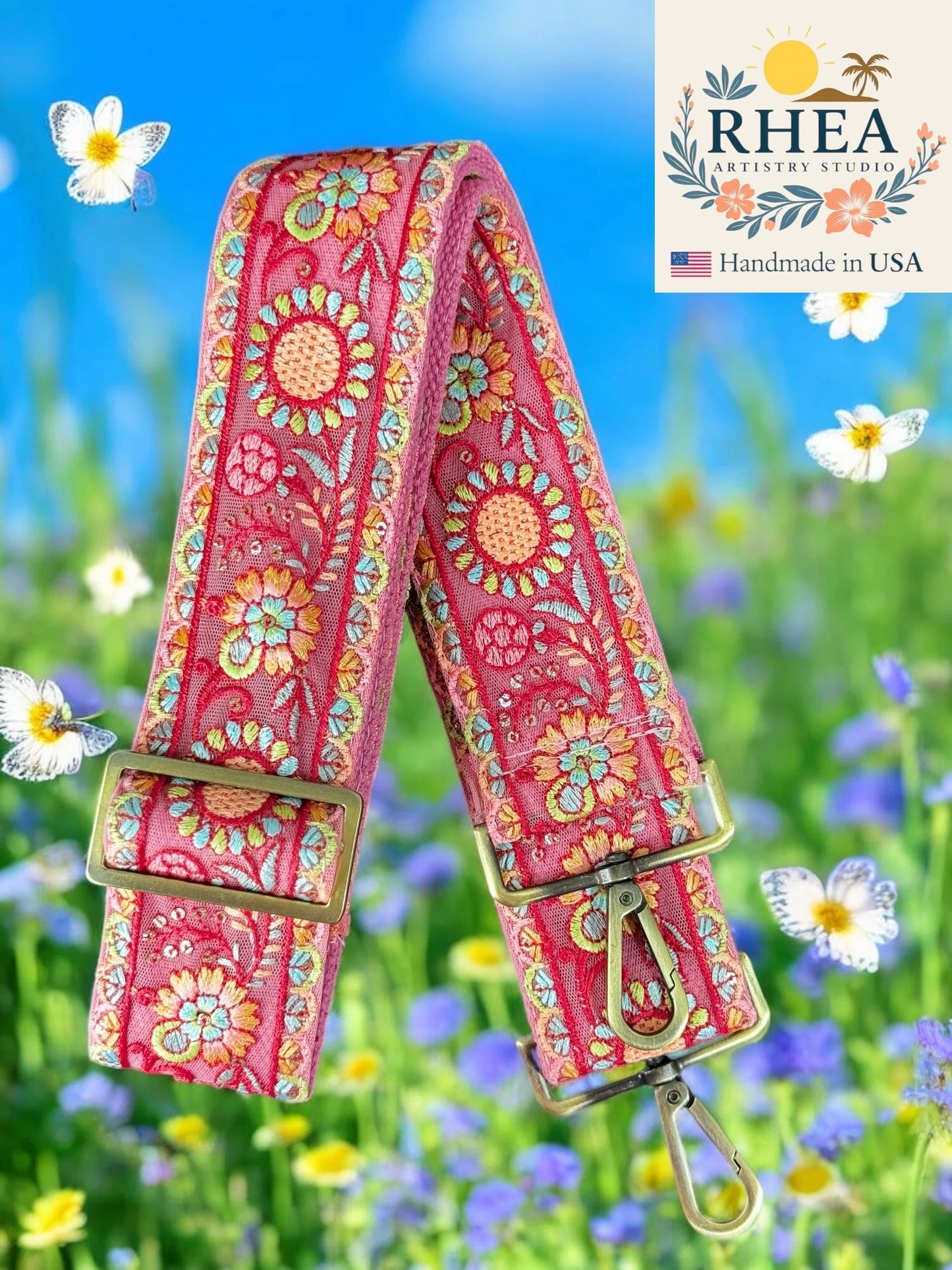 Colorful floral-patterned purse strap with gold hardware against a natural background