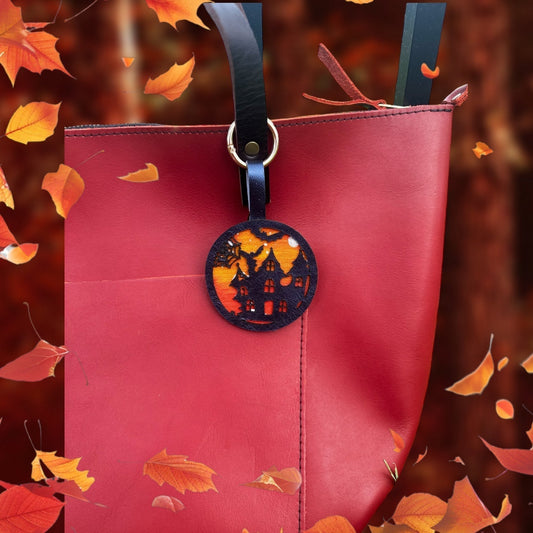 handpainted haunted house with bats and moon on a vegetable tan leather with lobster clasp