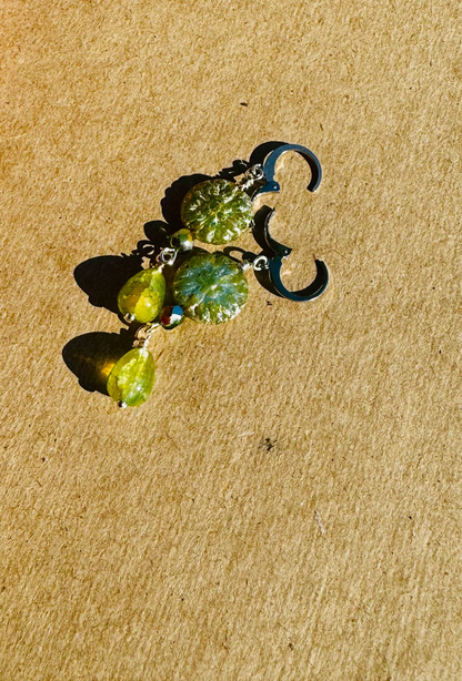 Gold earrings with green stones on old book