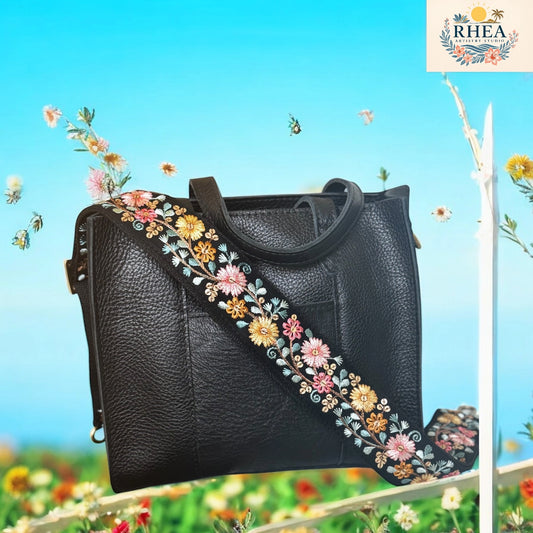Black handbag with floral embroidery on a blue sky background